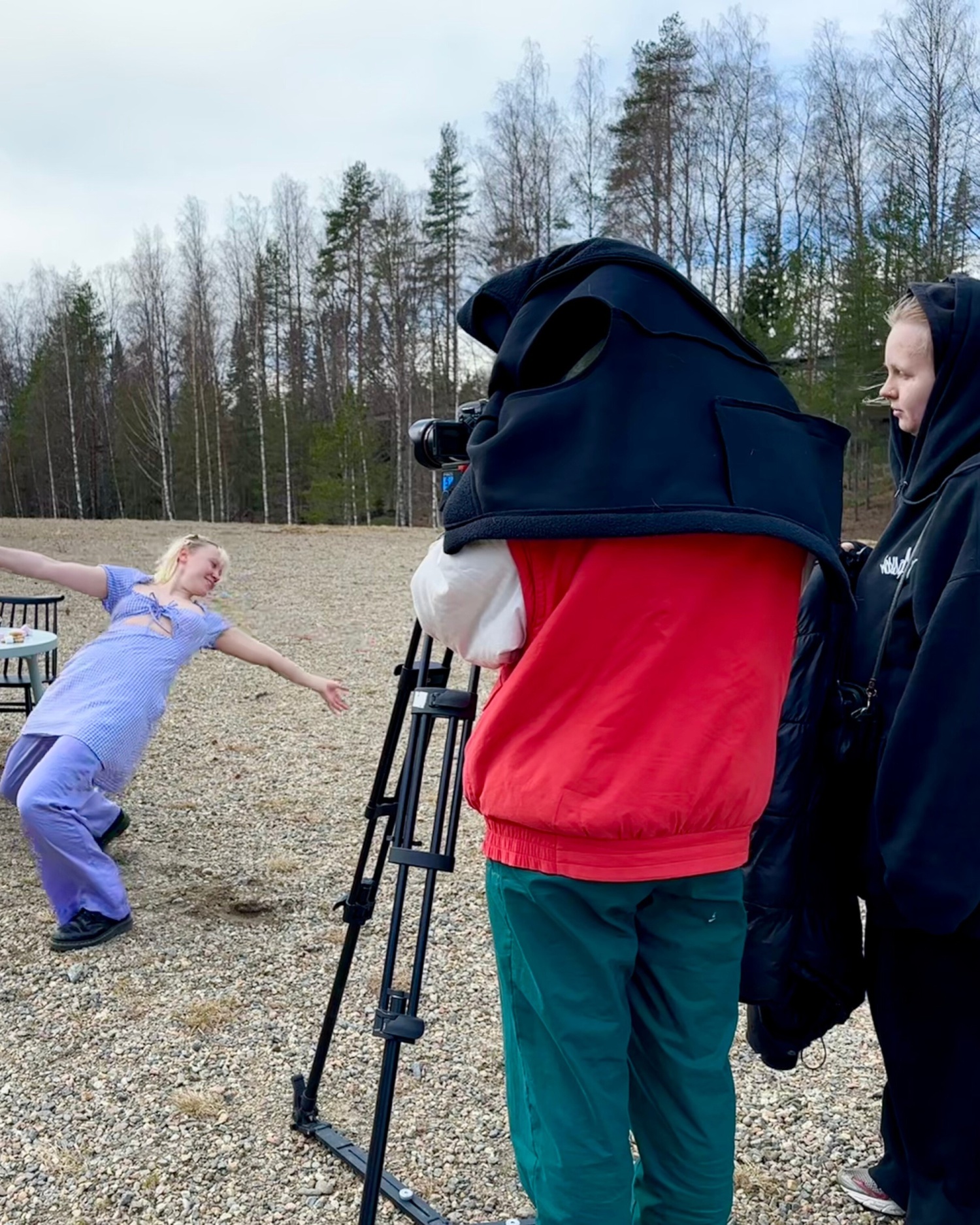 kaksi henkilöä kuvaa videokameralla kun kolmas tanssii