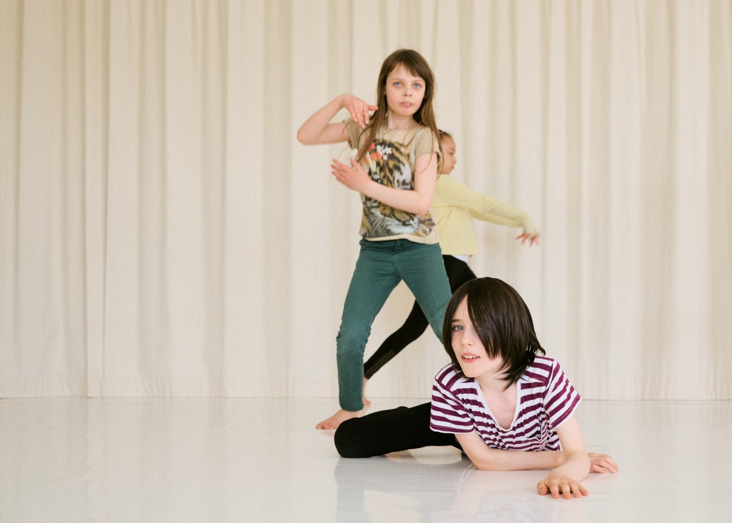 Tre dansande barn i en ljus rum