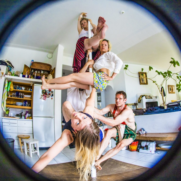 Neljä tanssijaa roikkuu olohuoneen tanssitangossa