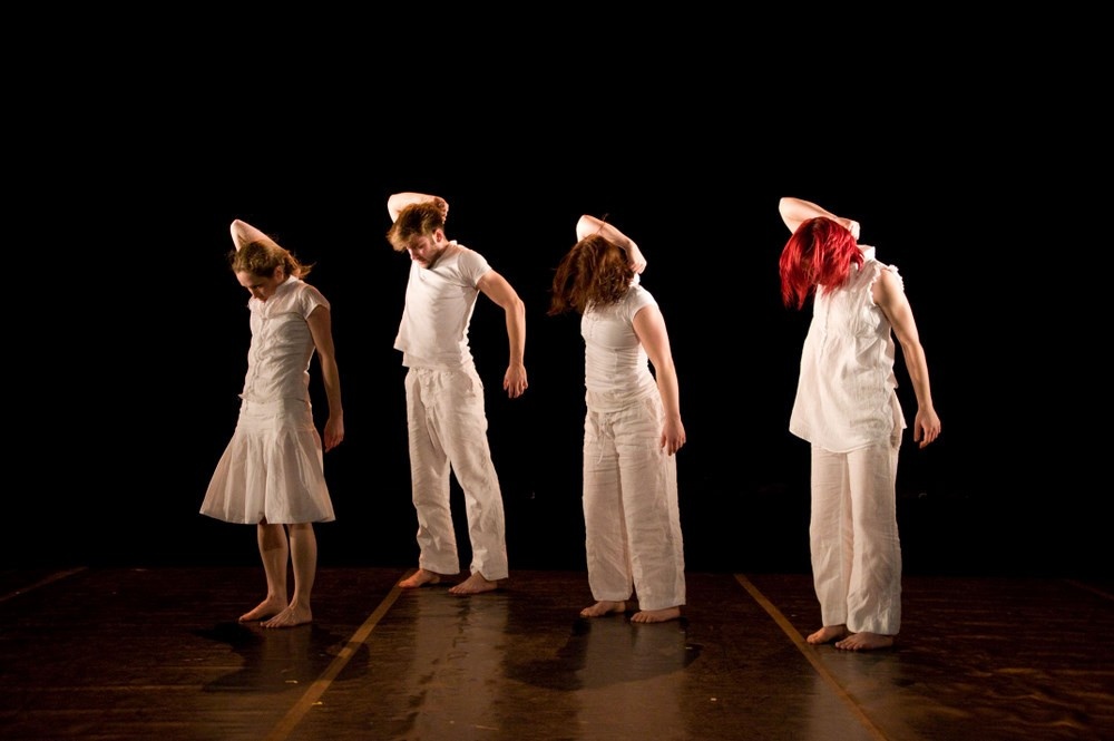 Four women dressed in white standin in a row