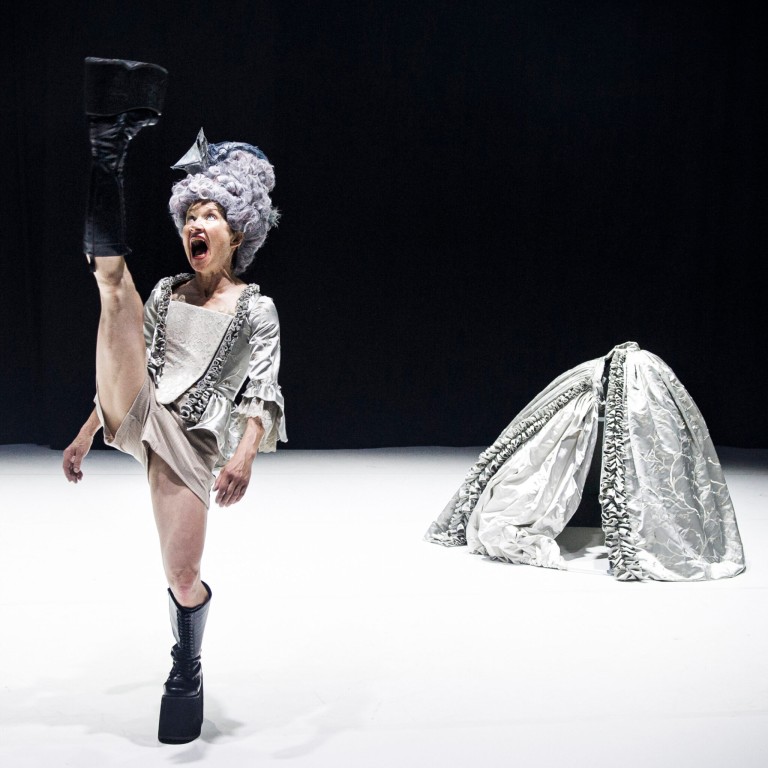 Dancer standing on one foot in silver clothing