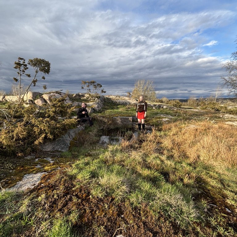 Nainen seisoo avarassa luontomaisemassa